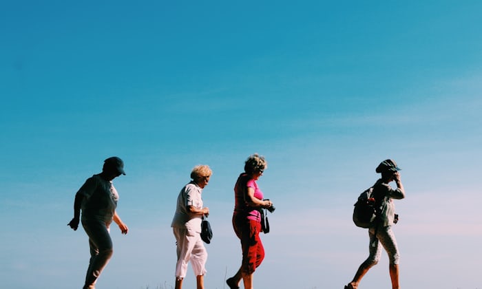 Group of active older friends walking outdoors together