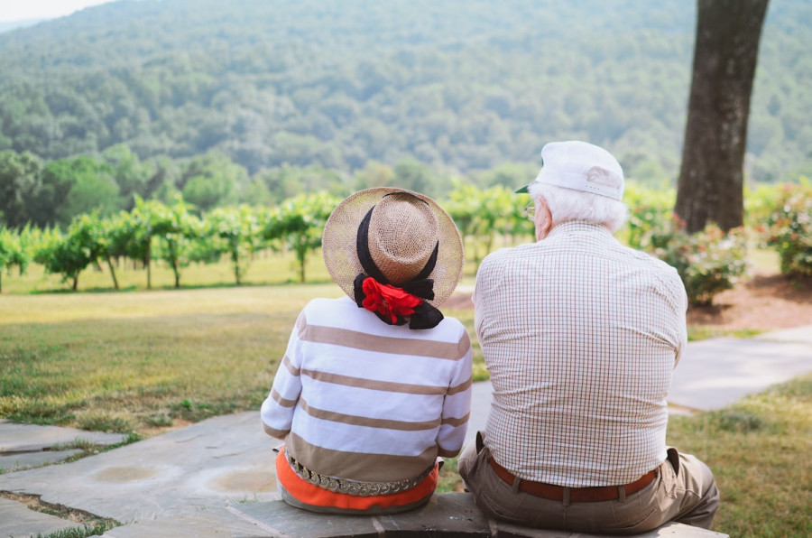 Elderly couple sitting together, enjoying a quiet outdoor view